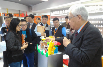 圖為龍華科大丁鯤副校長(右一)向與會來賓介紹該校3D列印機所製作出的產品。