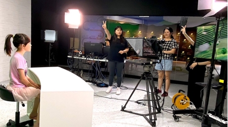 龍華文創系學生在世界客家博覽會「Open Studio」虛擬攝影棚提供民眾主播體驗。