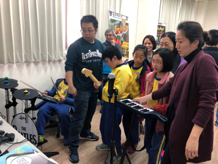 龍壽國小學童在數位內容中心，體驗龍華學子設計賽車、拳擊、電子琴及吉他等多種電動遊戲。
