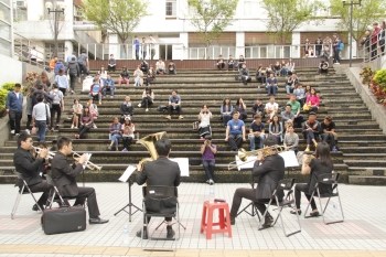 圖為於龍華階梯廣場聆聽藝聲管樂團 E-sound Band表演的學生。