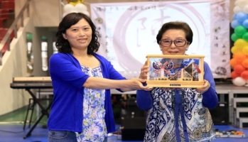 圖為高雄市觀光局高久雅小姐(左)贈送龍華成立十週年紀念座予龍華科技大學代表創辦人孫陳淑娟女士(右)。