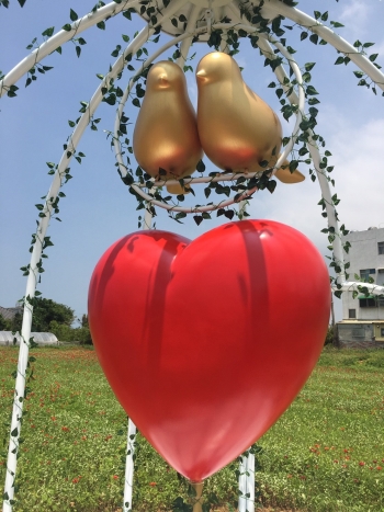 圖為〝愛心束〞作品近照，籠內是一棵紅色愛心花樹，一對小鳥相互依偎。象徵「愛」不該用牢籠束縛。