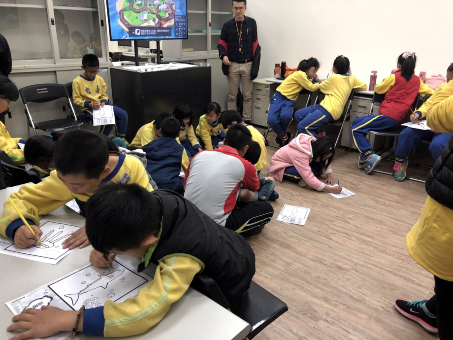 龍壽國小學童將魚畫在紙上，並透過平板掃描投射進電視螢幕中，開心體驗寓教於樂的校外教學。