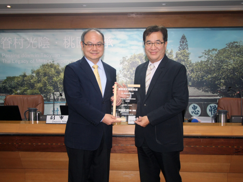 桃市副市長游建華(右)肯定龍華科大教育英才、創新有成的卓越成就，由葛自祥校長代表領獎。