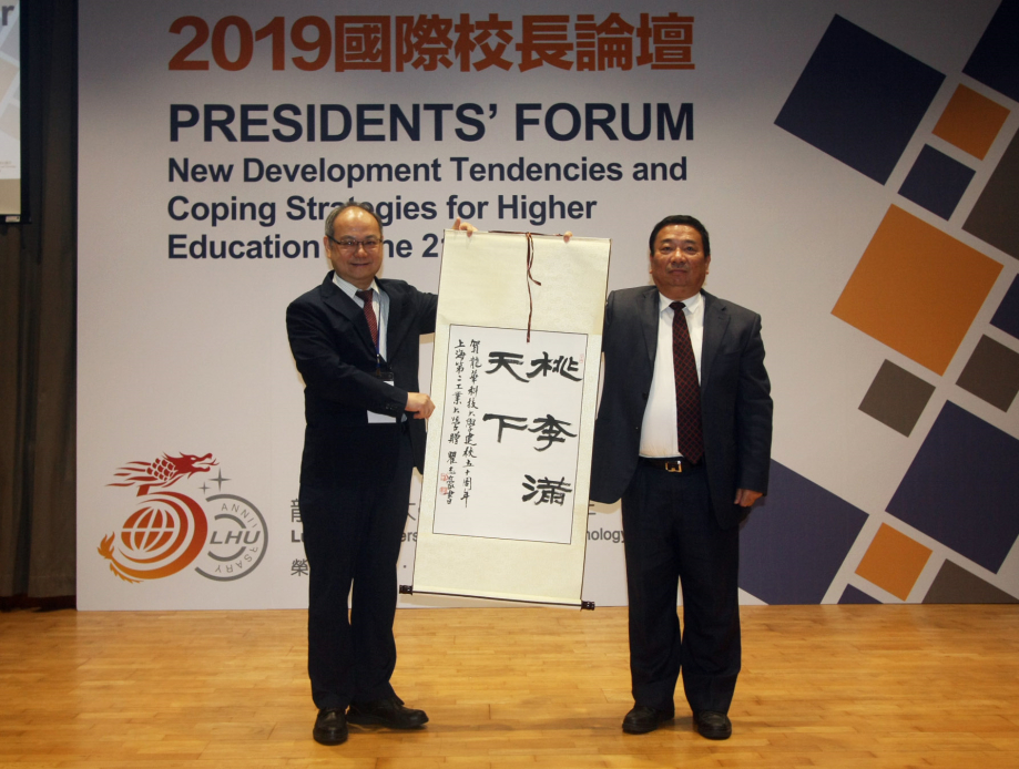 上海第二工業大學書記吳松(右)致贈紀念品，祝賀龍華科大50週年生日快樂。