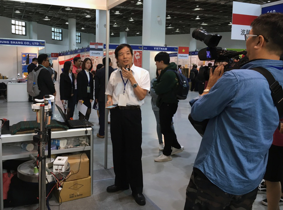 龍華科大文武教授接受媒體採訪說明「飲料製作機器人」。