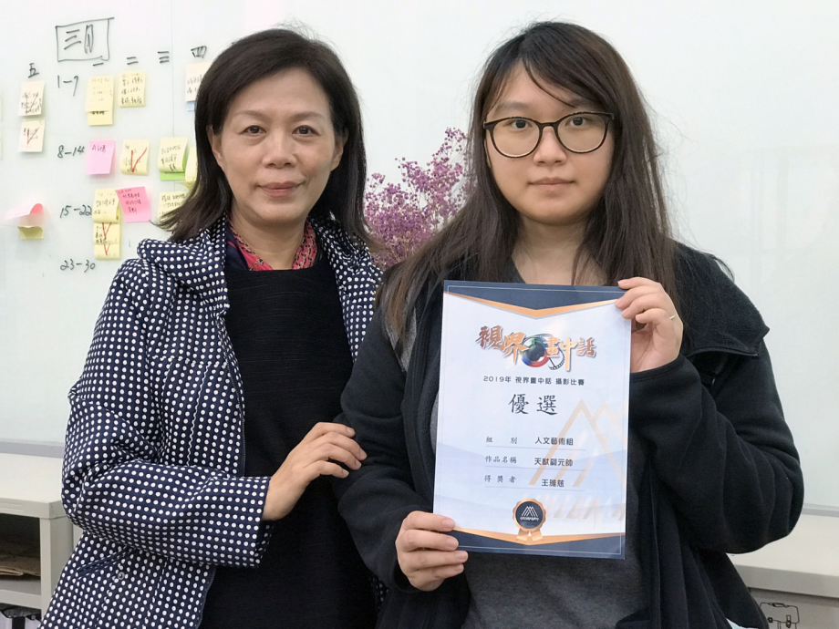 龍華科大文創系學生王雅慈獲《視界·畫中話》攝影競賽人文藝術組優選獎，系主任葉茉俐(左)給予肯定。