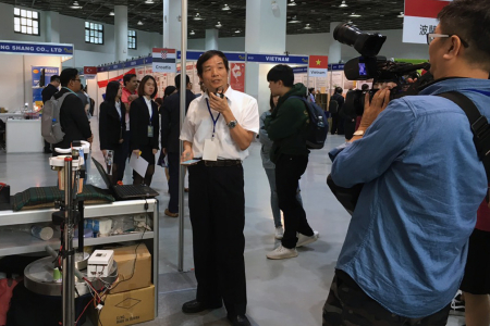 龍華科大文武教授接受媒體採訪說明「飲料製作機器人」。