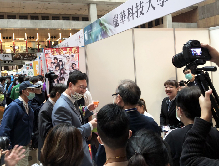 僑委會委員長童振源參觀龍華科大攤位，品嘗觀休系僑生手作咖啡及調酒技藝。