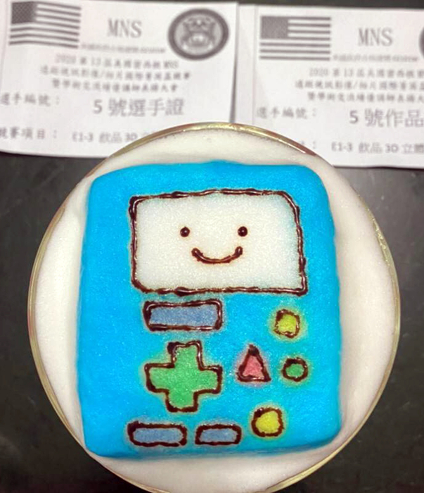 陳淑婷發揮童趣,將掌上型遊戲機雕塑在咖啡上,順利奪下3D咖啡雕花冠軍。