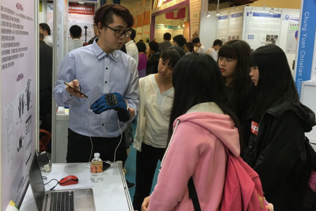 龍華科大胡淑珍老師團隊向參觀民眾示範「機車騎士手套」使用方法。