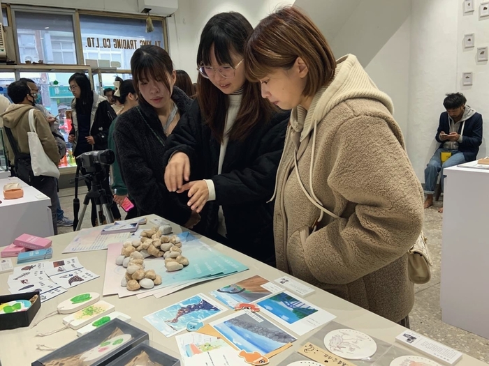 龍華學子為參觀民眾講解石滬桌遊的玩法。
