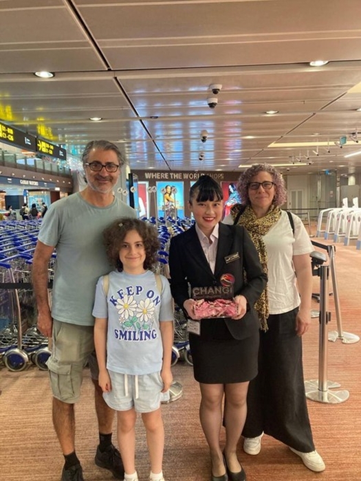 應用外語系林芷瑄同學於海外實習期間與旅客合影，展現服務精神與跨文化溝通能力。