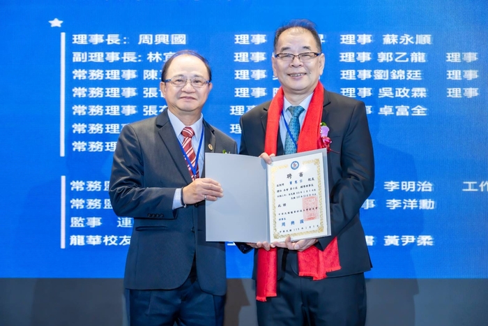 新舊任理事長完成交接，新任第十屆理事長周興國（左）與卸任第九屆理事長竇憲宗（右）相互致意，象徵校友情誼的傳承。