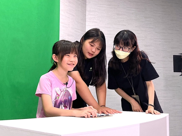 參觀世界客家博覽會民眾可在「Open Studio」實際體驗主播播報新聞流程。圖片