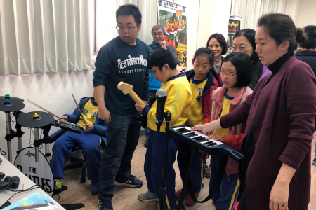 龍壽國小學童在數位內容中心，體驗龍華學子設計賽車、拳擊、電子琴及吉他等多種電動遊戲。