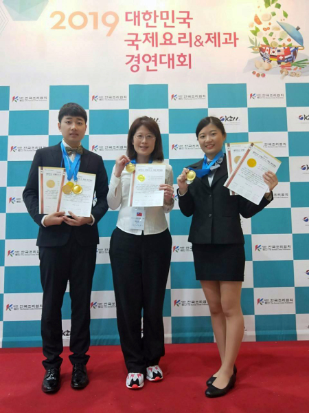 龍華科大觀休系謝美婷老師(中)指導許智婷及林陳進，參加2019 KICC韓國國際餐飲大賽獲3金2銀佳績。