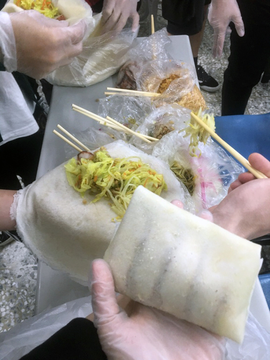 學生展示包好的潤餅，有越南春捲的模樣。