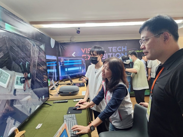 桃市青年局長侯佳齡，親自體驗龍華科大學子製作的遊戲。